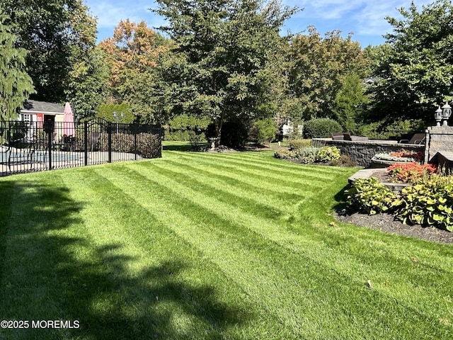 view of yard with fence, a pool, and a patio