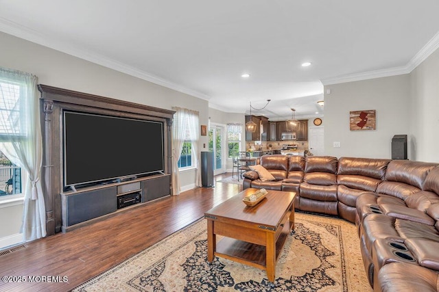 living room featuring visible vents, crown molding, baseboards, recessed lighting, and light wood finished floors