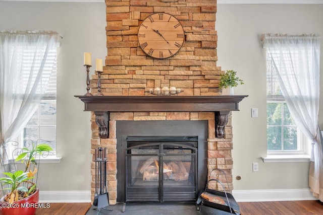 interior details featuring baseboards, wood finished floors, and a fireplace