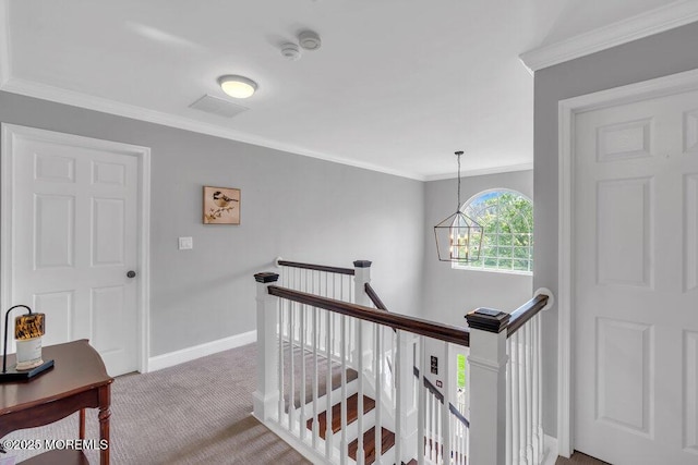 corridor with carpet flooring, baseboards, an upstairs landing, and ornamental molding