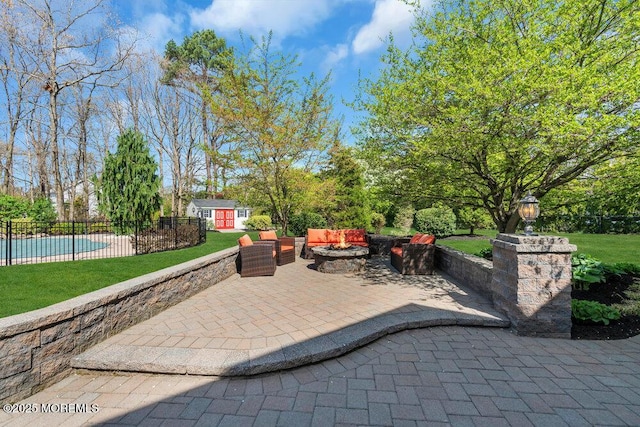 view of patio featuring a storage shed, an outbuilding, fence, a fenced in pool, and an outdoor living space with a fire pit