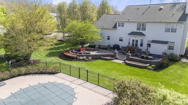 back of house with a yard, a patio, a fenced backyard, and an outdoor fire pit