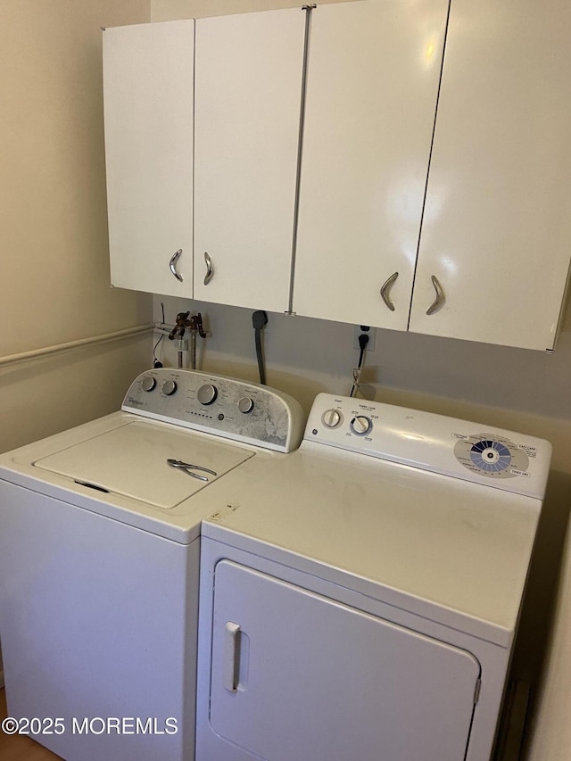 washroom featuring separate washer and dryer and cabinet space