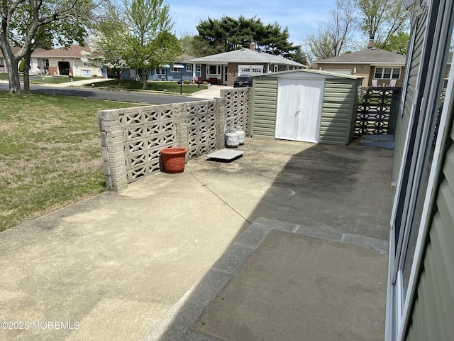 view of patio featuring a storage shed, a residential view, and an outdoor structure