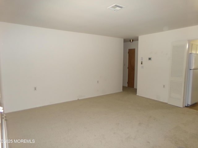 empty room with light colored carpet and visible vents