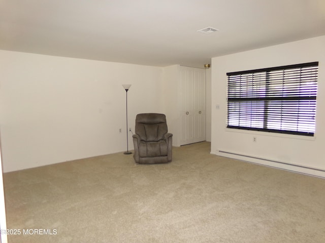 unfurnished room featuring light colored carpet, a baseboard radiator, and visible vents
