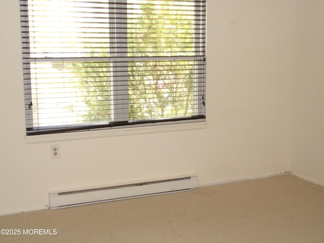 carpeted empty room featuring a baseboard radiator