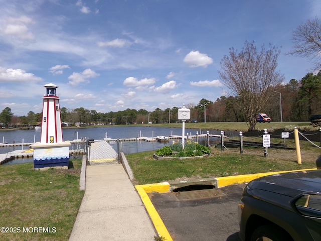 view of dock featuring a gate, a water view, and fence
