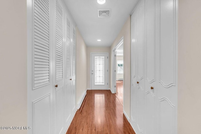 corridor featuring recessed lighting, wood finished floors, visible vents, and baseboards