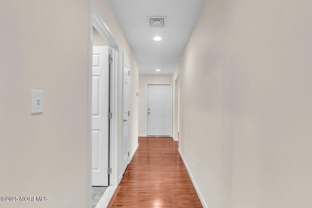 hallway with recessed lighting, light wood-style floors, visible vents, and baseboards