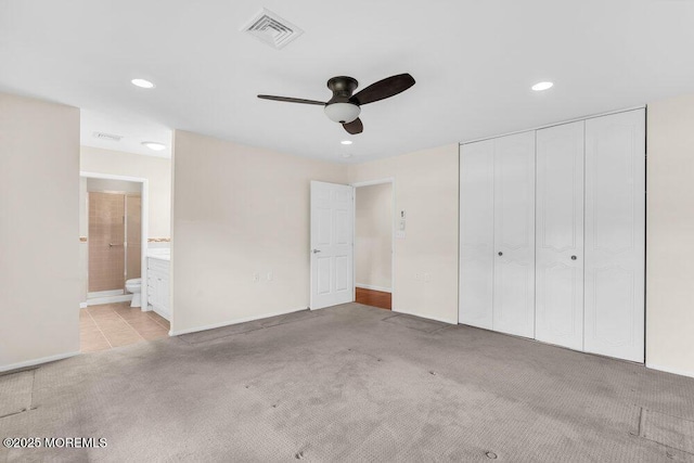 unfurnished bedroom featuring ensuite bathroom, a closet, light carpet, visible vents, and recessed lighting