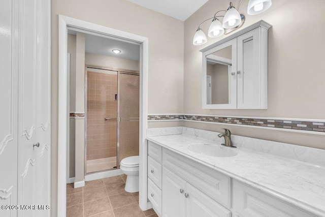 full bath featuring a shower stall, toilet, vanity, and tile patterned floors