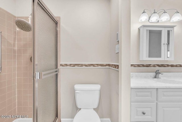 bathroom with vanity, a shower stall, and toilet