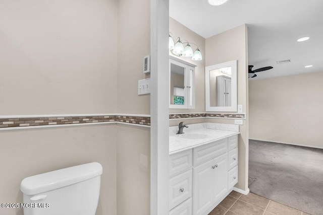 bathroom with tile patterned floors, toilet, visible vents, ceiling fan, and vanity