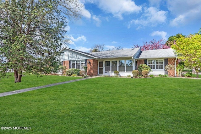 ranch-style house featuring brick siding and a front yard