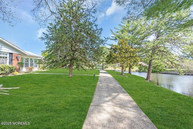 view of community with a lawn and a water view