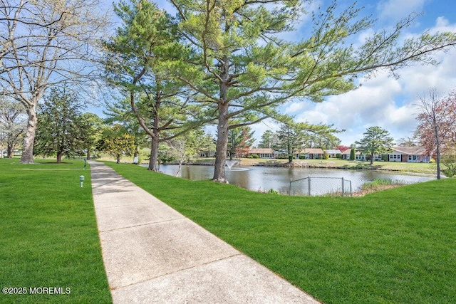 view of home's community with a yard and a water view