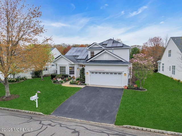 traditional-style house with a garage, driveway, roof mounted solar panels, and a front lawn