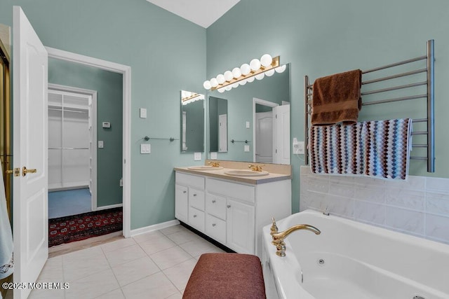 full bathroom featuring a tub with jets, a sink, tile patterned flooring, and double vanity