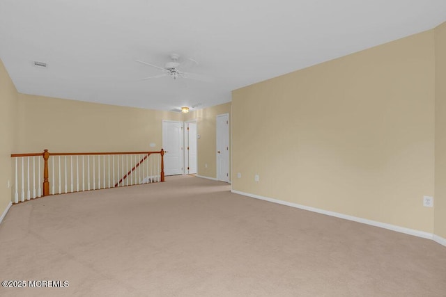 carpeted empty room featuring baseboards, ceiling fan, and visible vents