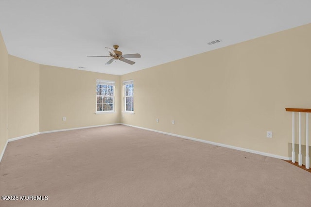 empty room with baseboards, a ceiling fan, light colored carpet, and visible vents