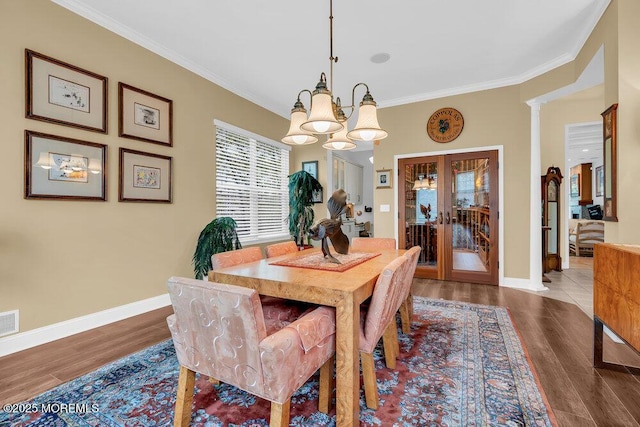 dining room with french doors, ornamental molding, baseboards, and a chandelier