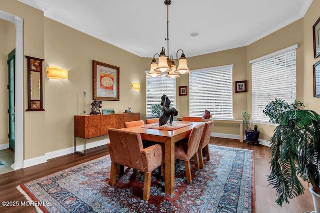 dining area with an inviting chandelier, baseboards, ornamental molding, and wood finished floors