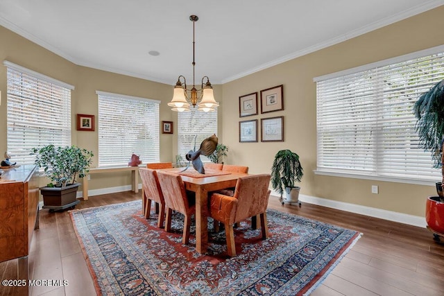 dining area with crown molding, baseboards, an inviting chandelier, and wood finished floors