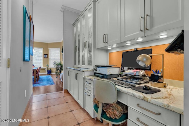 office area with light tile patterned floors, baseboards, and ornamental molding