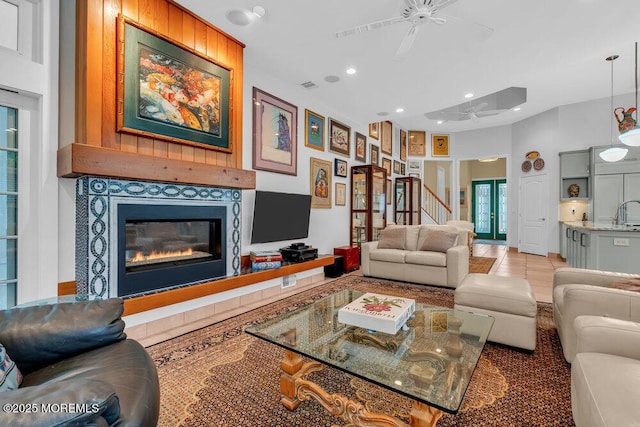 living room with visible vents, a glass covered fireplace, ceiling fan, recessed lighting, and light tile patterned floors