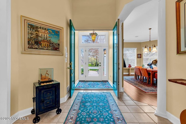 foyer entrance featuring baseboards and light tile patterned flooring