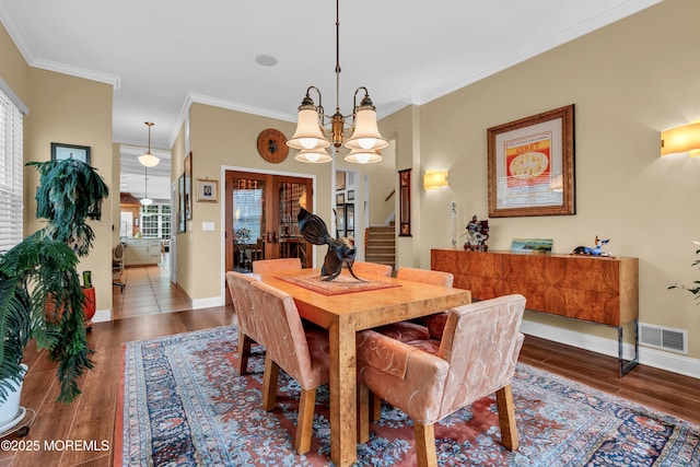 dining room featuring crown molding, baseboards, stairway, and visible vents