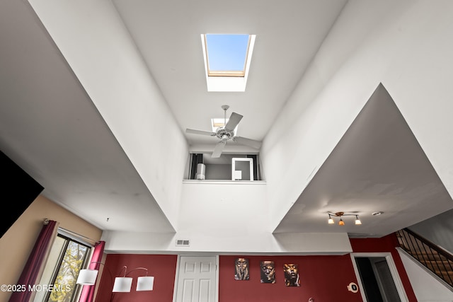 interior space featuring visible vents, a skylight, and ceiling fan