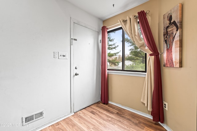 interior space featuring wood finished floors, visible vents, and baseboards