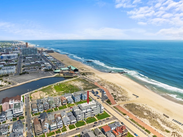 aerial view of property and surrounding area with waterfront with a beach