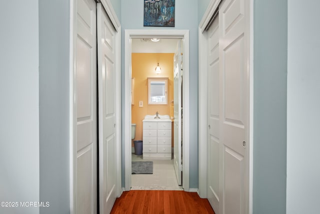 hall featuring a sink and dark wood-style floors