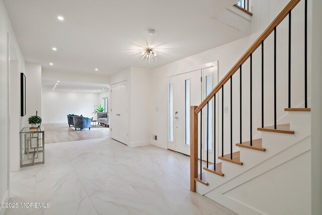 foyer featuring recessed lighting, baseboards, marble finish floor, and stairs