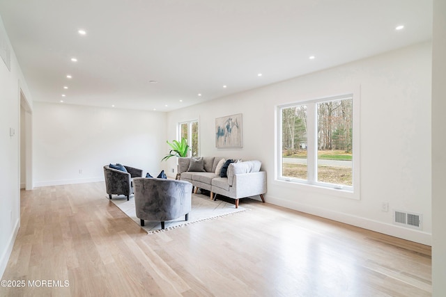 living area featuring recessed lighting, light wood-type flooring, visible vents, and baseboards