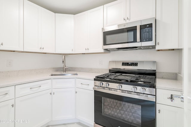 kitchen with white cabinetry, stainless steel appliances, and a sink