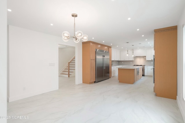 kitchen with backsplash, recessed lighting, premium appliances, and a kitchen island