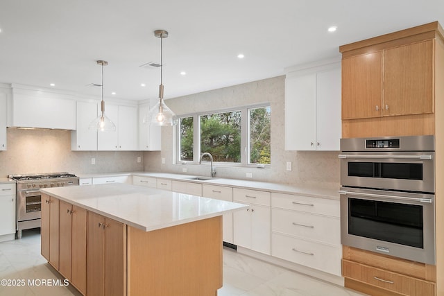 kitchen with marble finish floor, stainless steel appliances, backsplash, a sink, and a center island