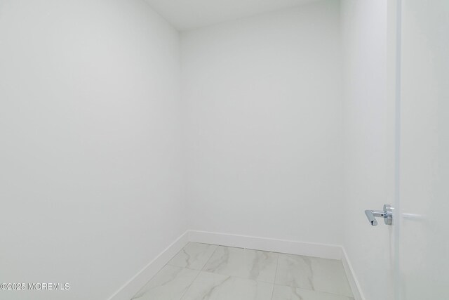 walk in closet featuring marble finish floor