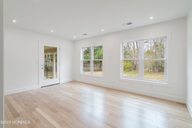 unfurnished room with recessed lighting, visible vents, light wood finished floors, and baseboards