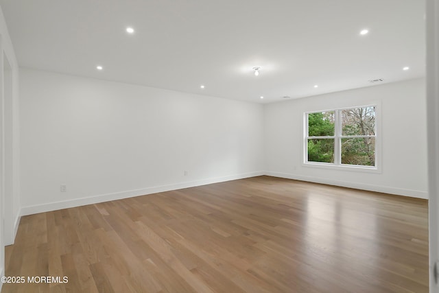 empty room with recessed lighting, visible vents, light wood finished floors, and baseboards