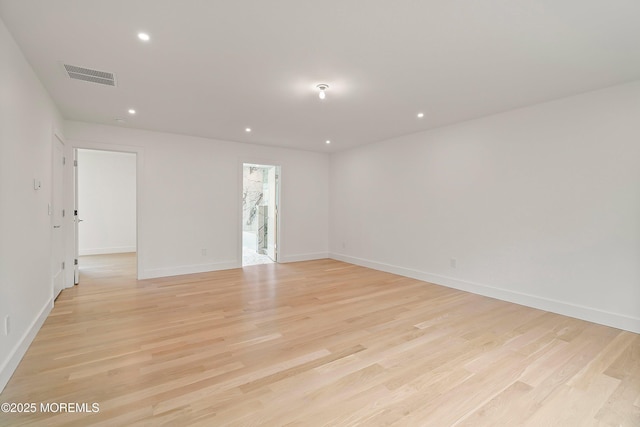 unfurnished room with baseboards, light wood finished floors, visible vents, and recessed lighting
