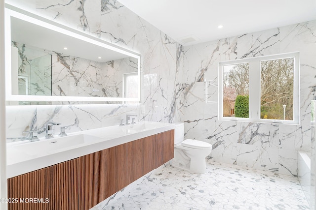 full bathroom featuring tile walls, a sink, double vanity, and toilet