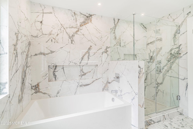 bathroom with tile walls, a bathing tub, and a marble finish shower