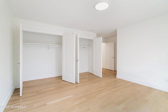 unfurnished bedroom with light wood finished floors and baseboards