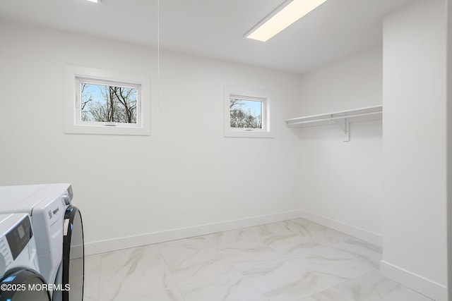laundry room with separate washer and dryer, a wealth of natural light, marble finish floor, and laundry area