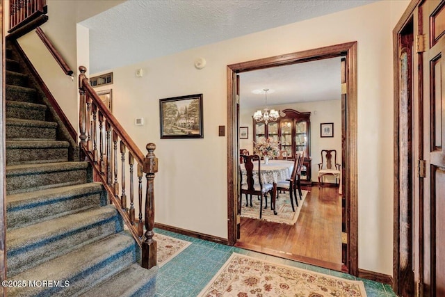 interior space with a textured ceiling, baseboards, and a chandelier